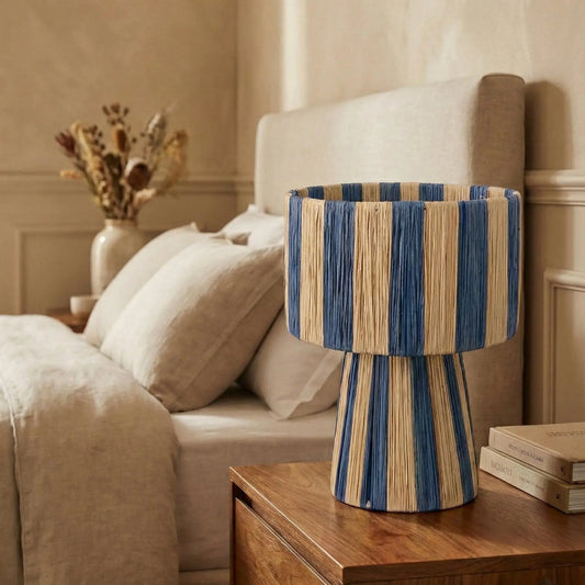 Striped lamp on a wooden side table in a bedroom setting