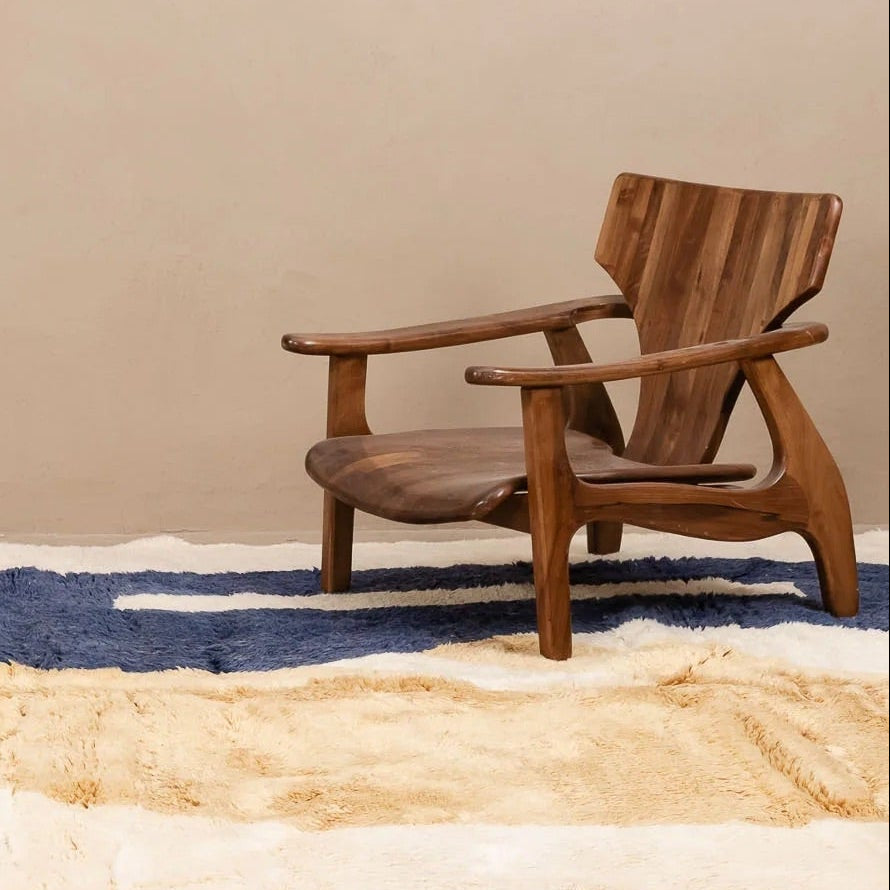Wooden chair on a patterned rug against a beige wall