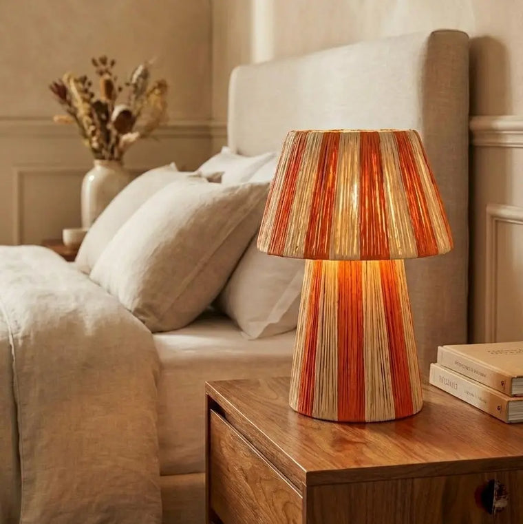 Decorative lamp on a nightstand next to a bed in a bedroom setting