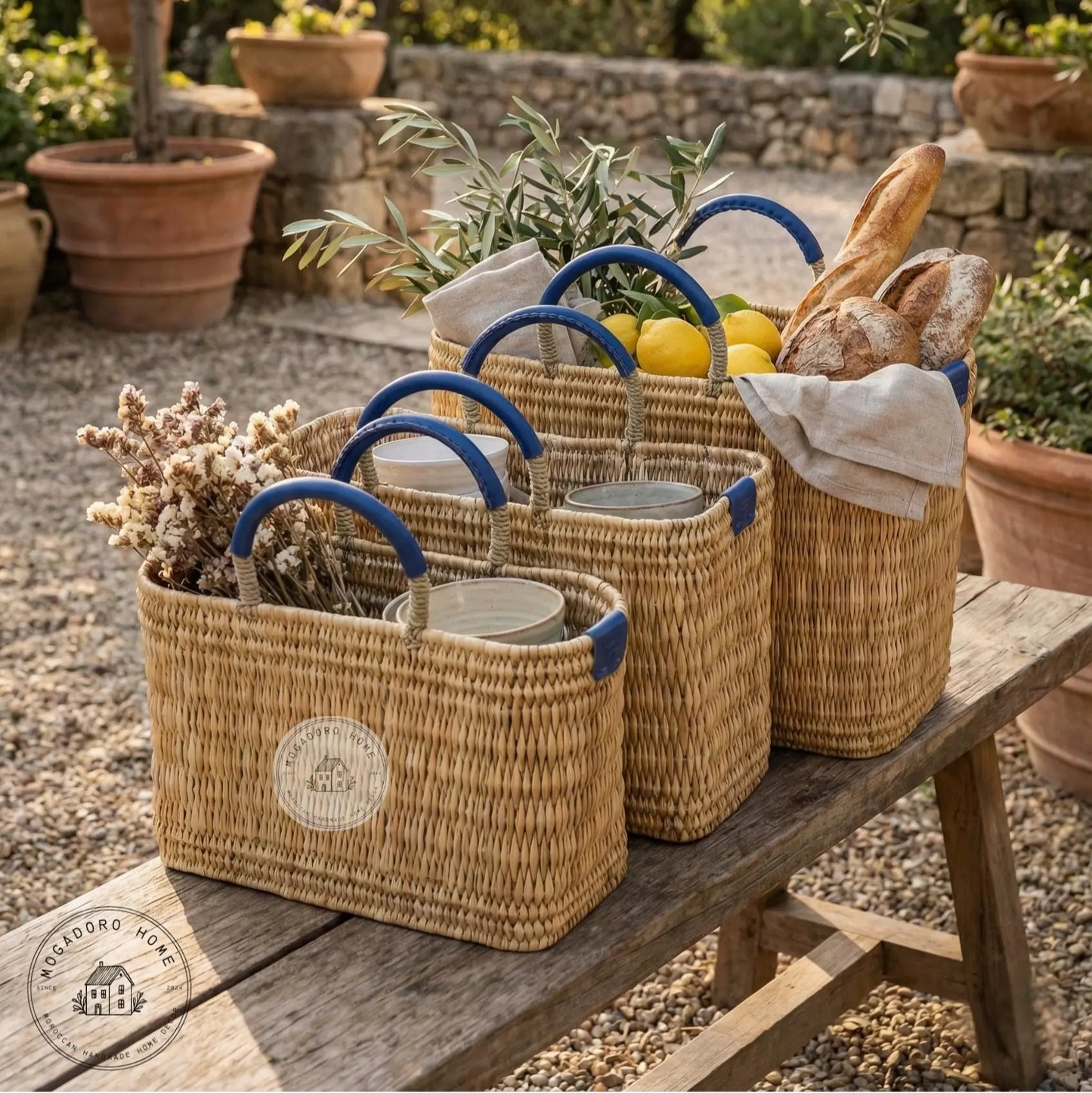 Woven baskets with blue handles on a wooden table outdoors.