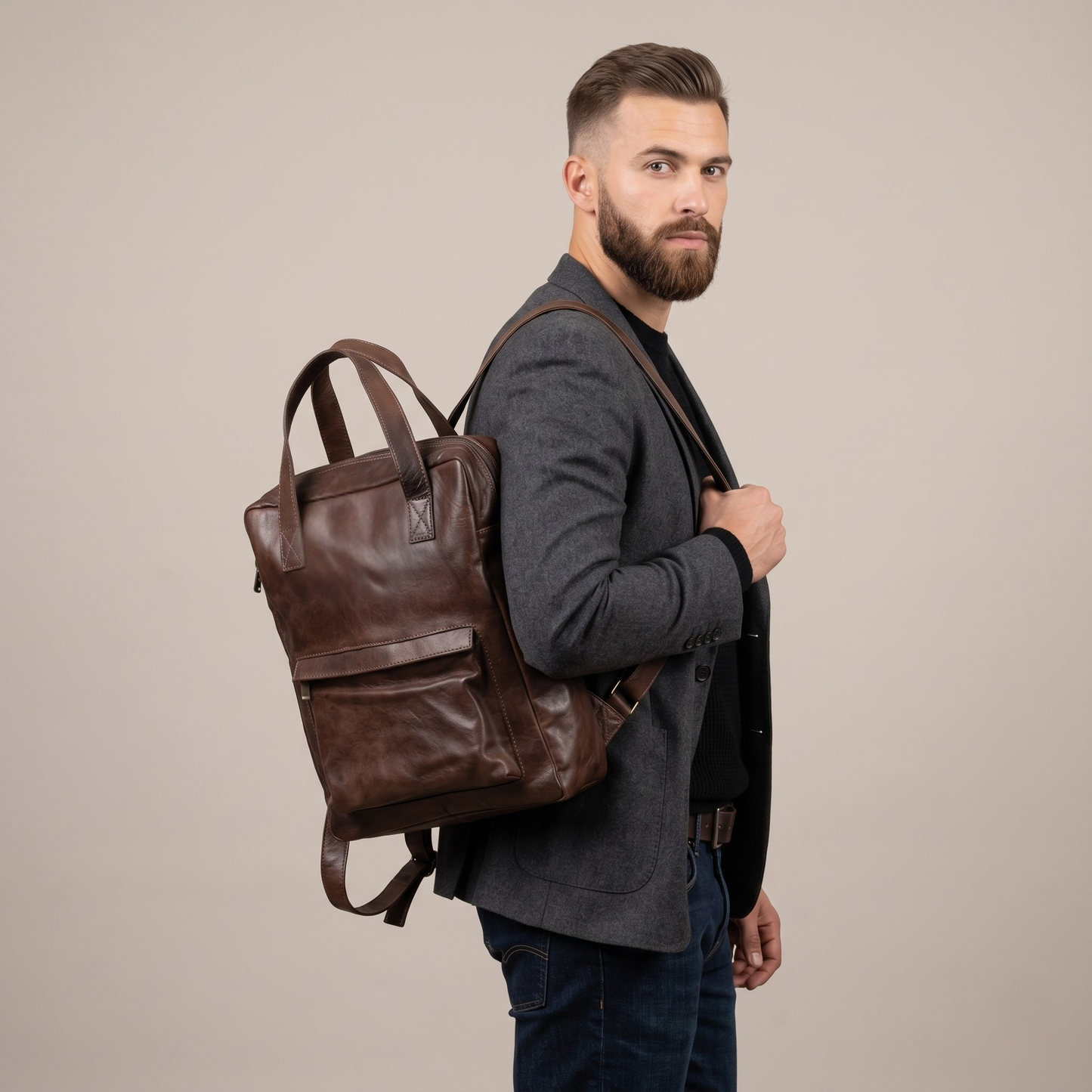 Man wearing a brown leather backpack against a beige background