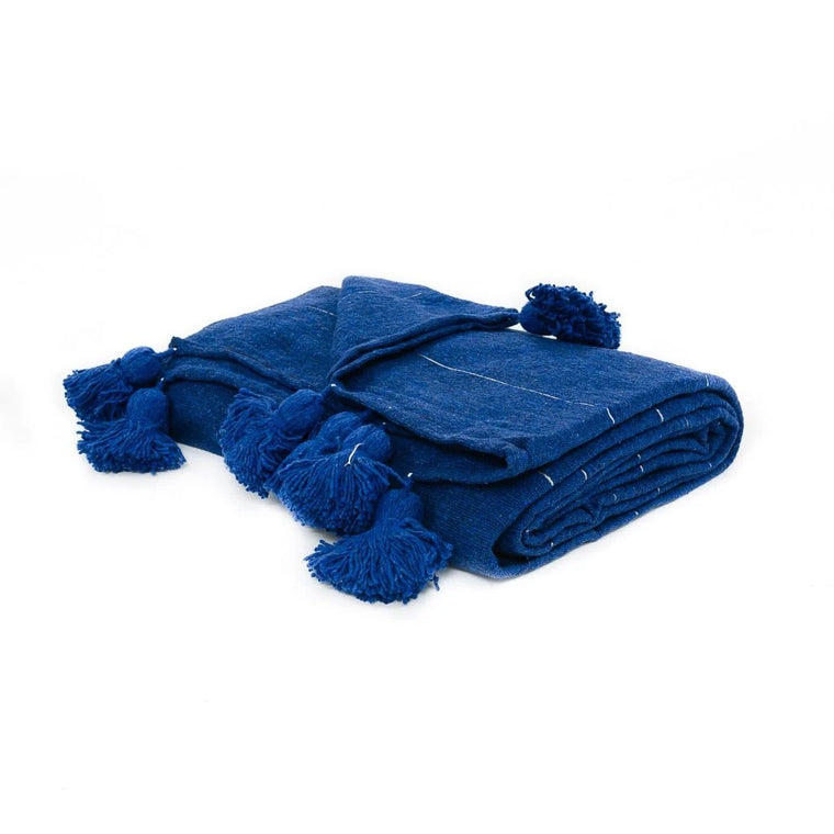 Blue blanket with pom-pom details on a white background