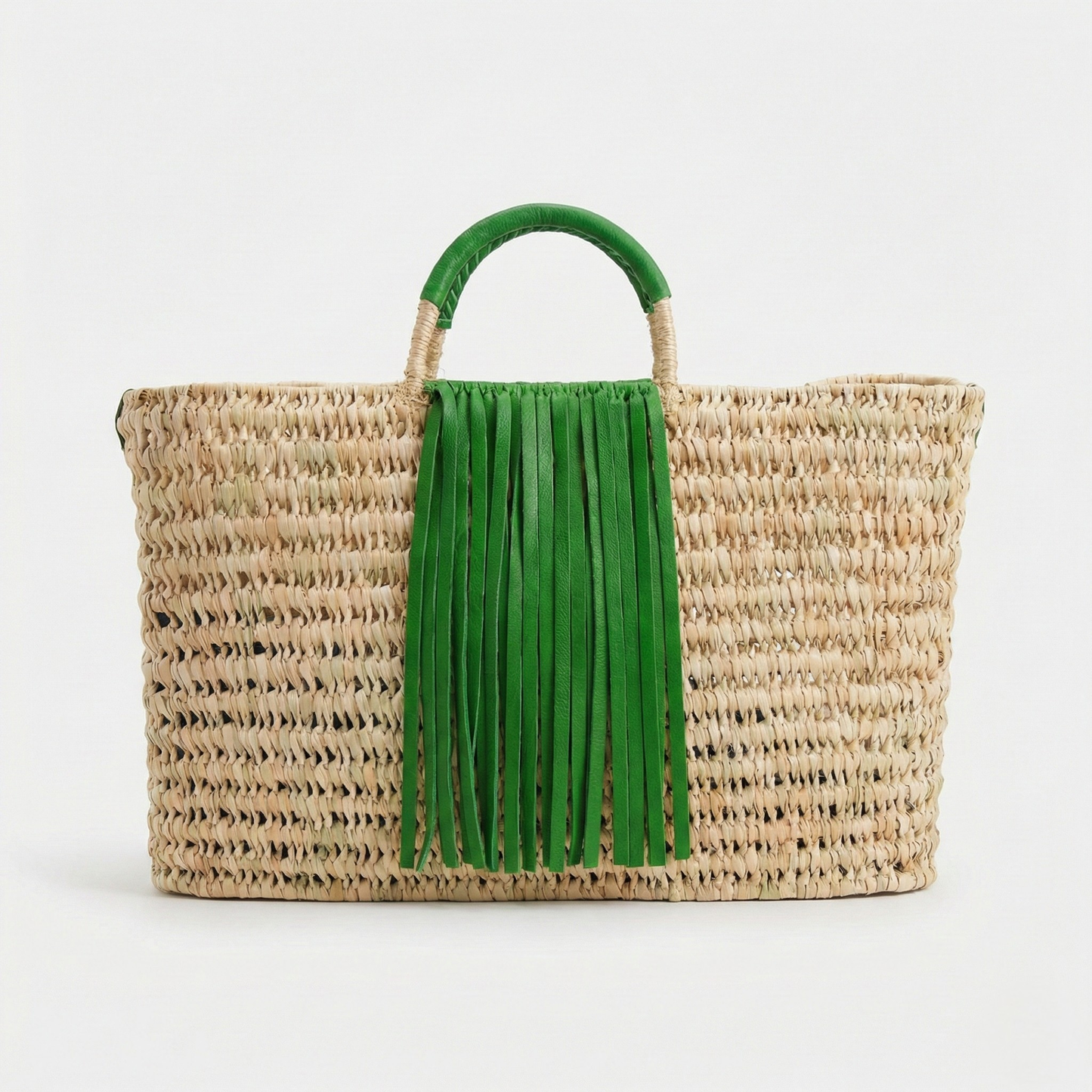 Woven bag with green fringe handle on a white background