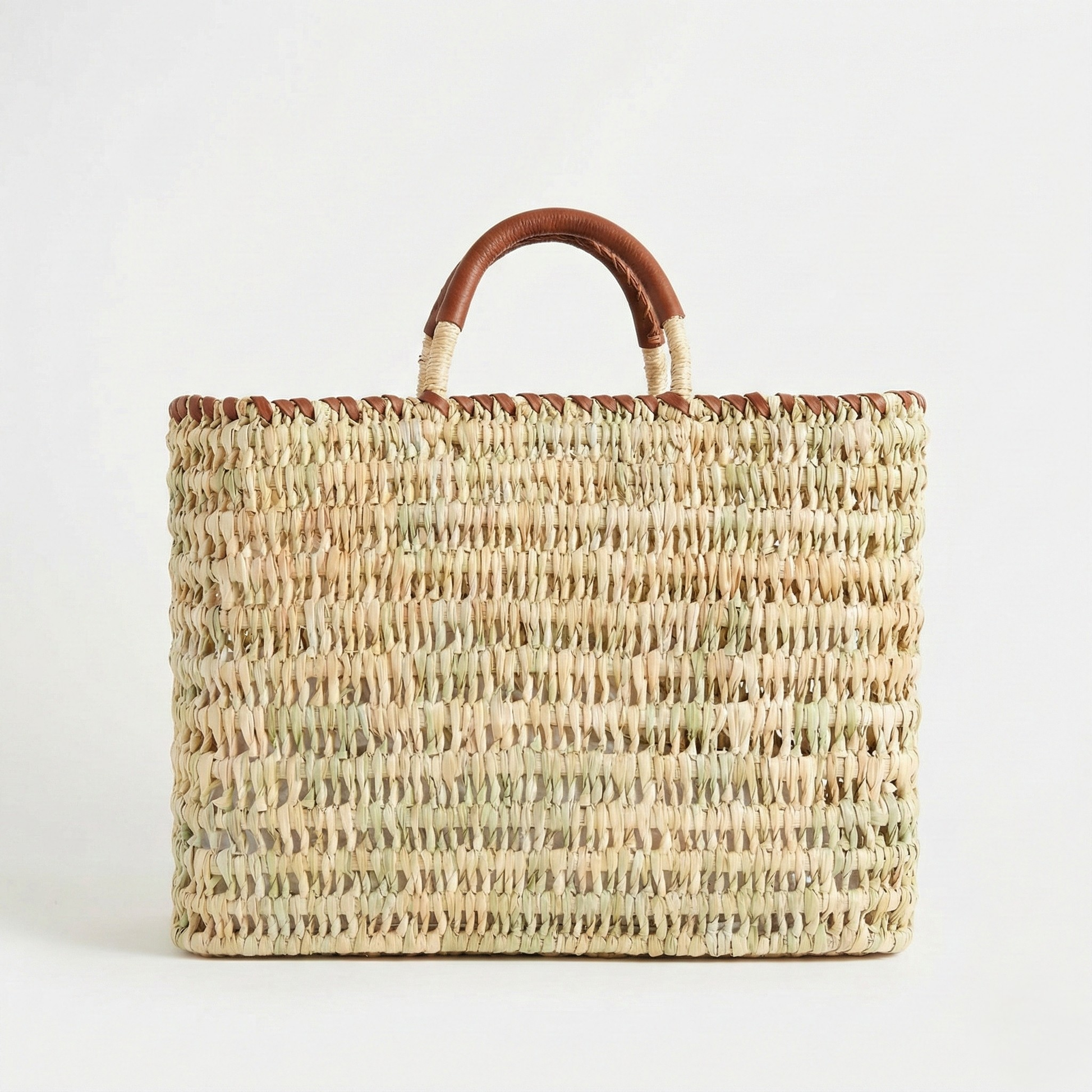 Woven handbag with brown handles on a white background