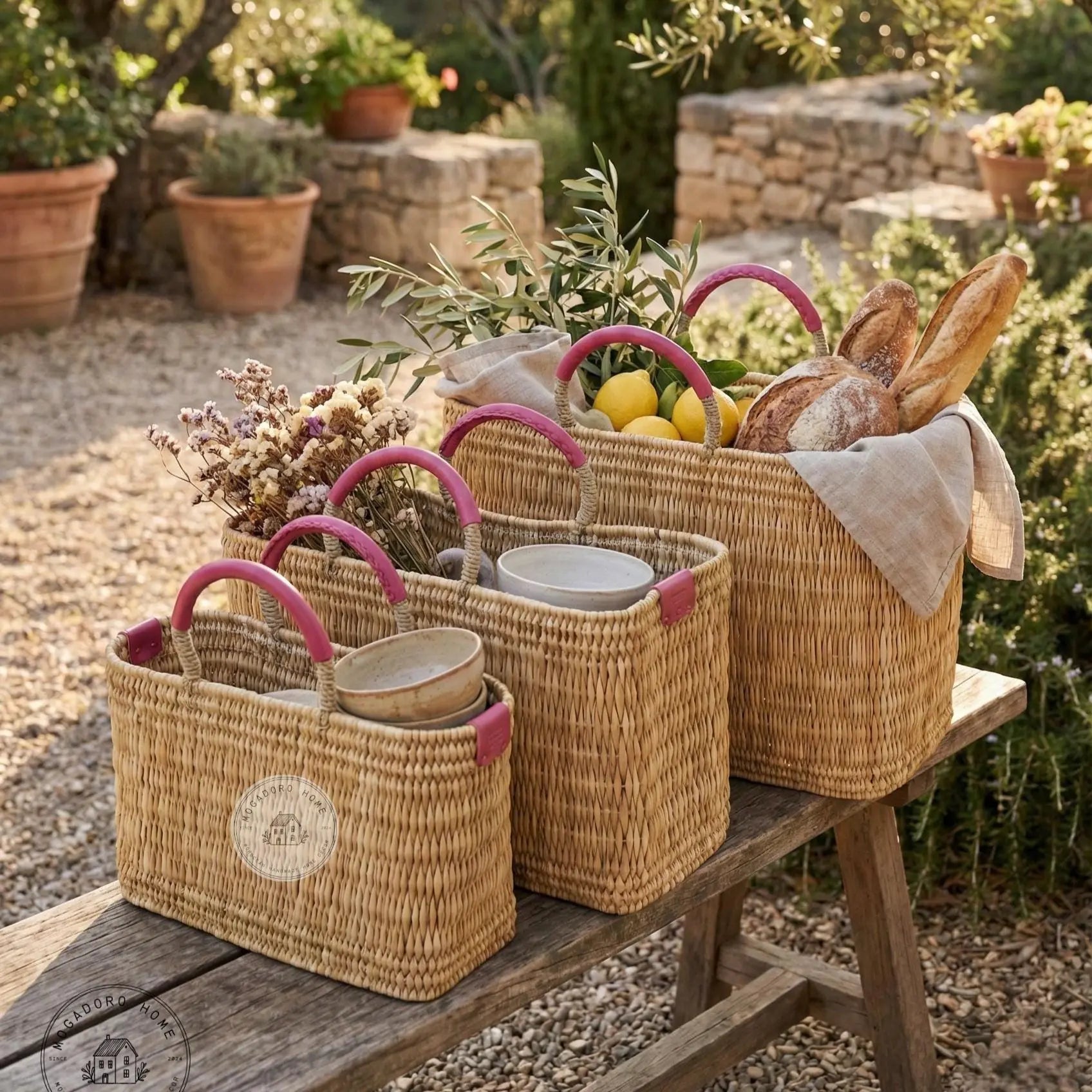 Wicker baskets with pink handles on a wooden table outdoors.