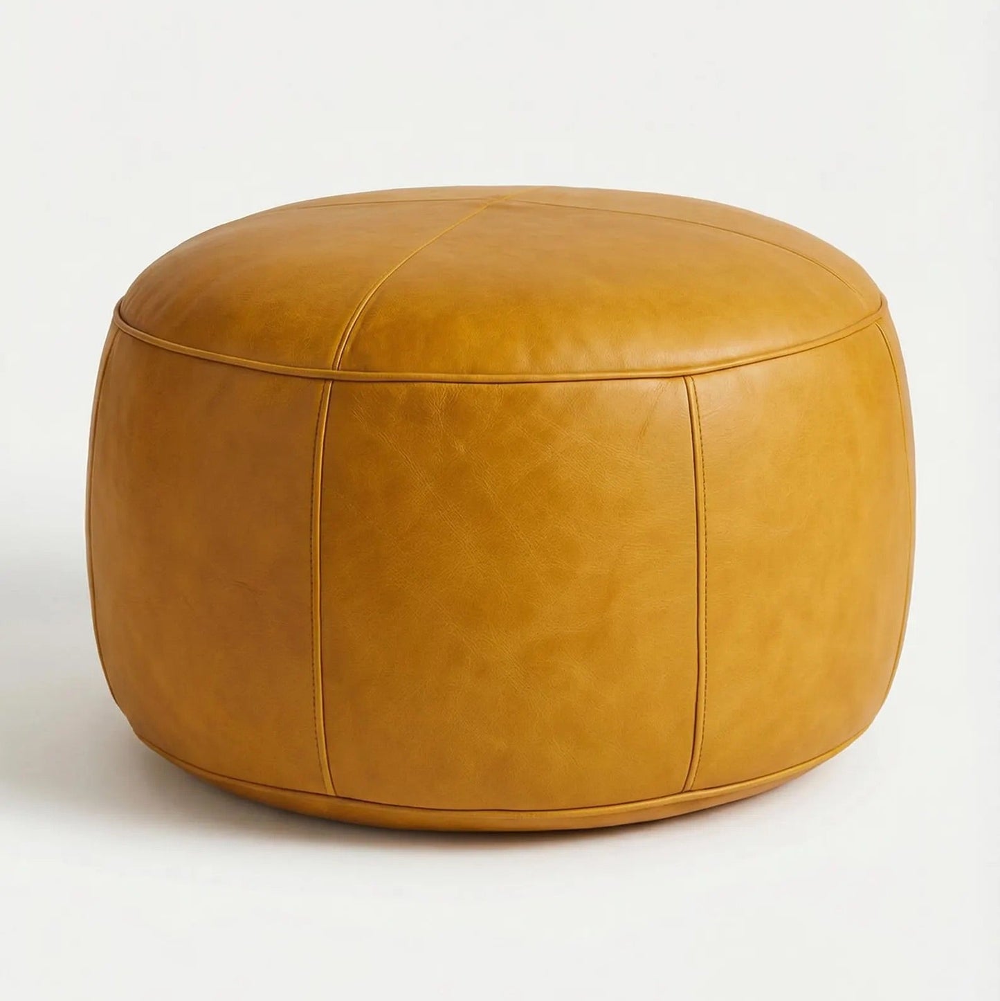 Round tan leather ottoman on a white background