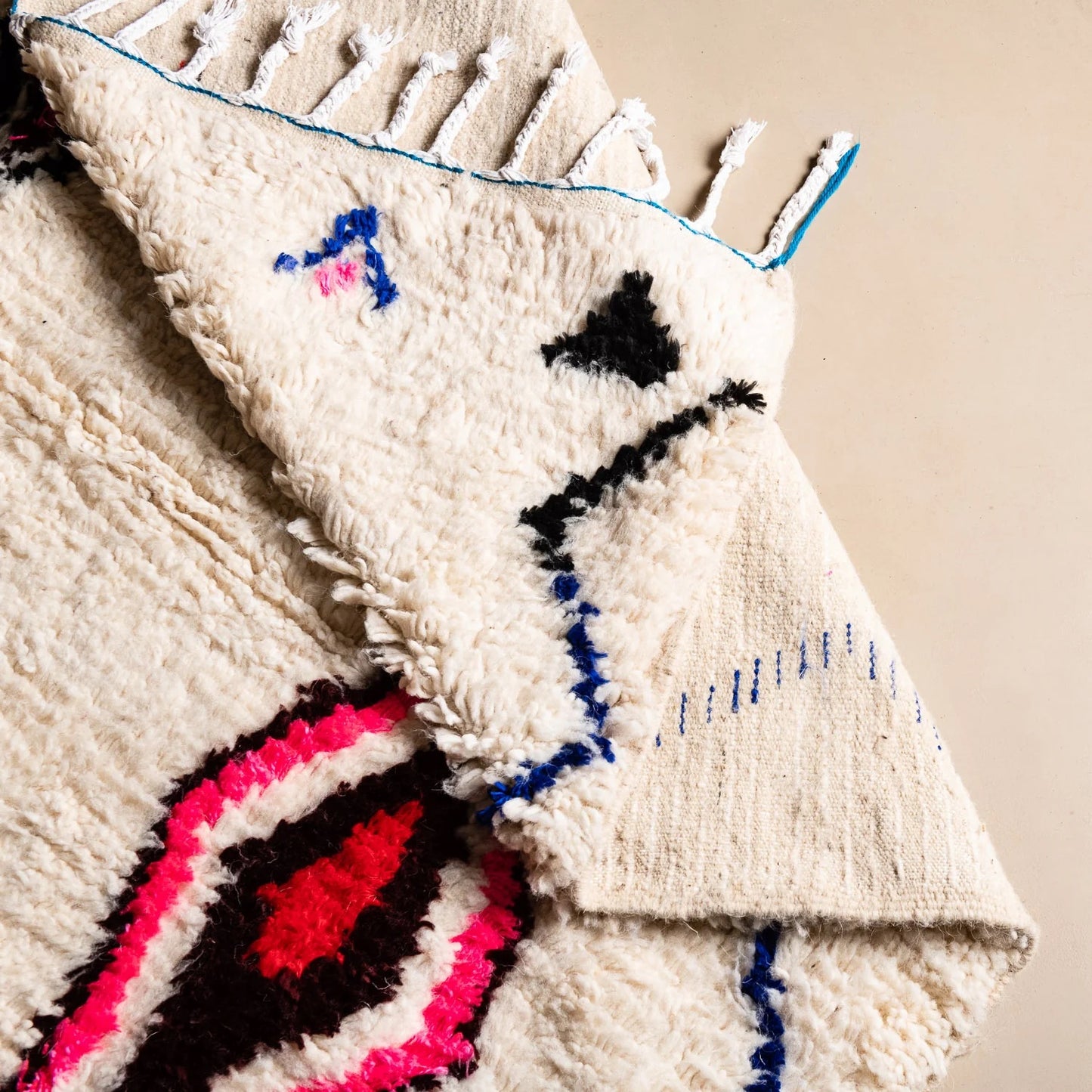 Textile art piece with geometric patterns on a beige background
